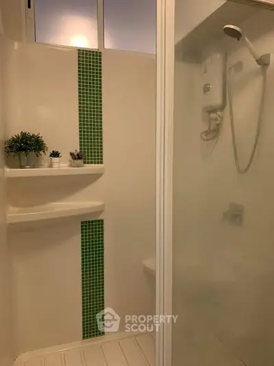 Modern bathroom with shower and green tile accent