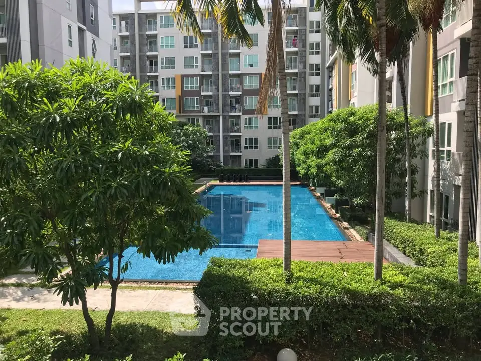 Luxurious condominium with a stunning pool surrounded by lush greenery and modern architecture.