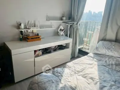 Modern bedroom with balcony and city view, featuring sleek white furniture and cozy bedding.