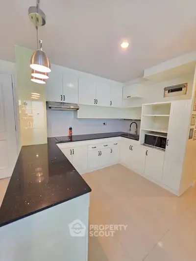Spacious modern kitchen with sleek countertops and ample storage in a bright, open layout.