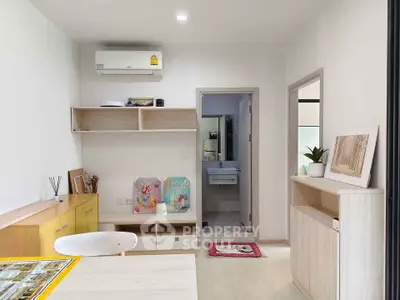 Modern living room with minimalist decor and air conditioning, featuring open shelving and a view into the bathroom.