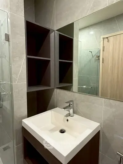 Modern bathroom with sleek sink and mirrored cabinet in stylish apartment.