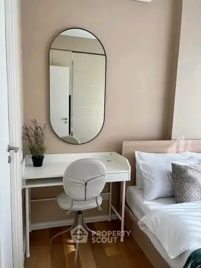 Cozy bedroom with modern desk and stylish mirror, perfect for a serene living space.