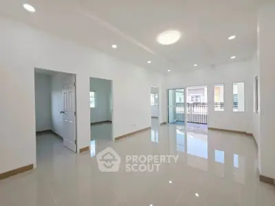 Spacious modern living room with large windows and balcony access