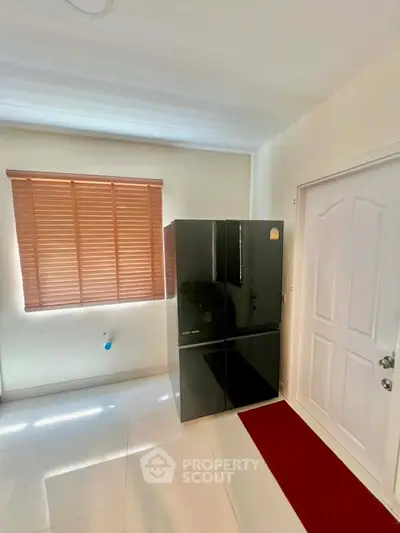 Modern kitchen with sleek black refrigerator and white door