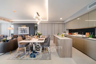 Luxurious open-plan living and dining area with modern kitchen in elegant apartment.