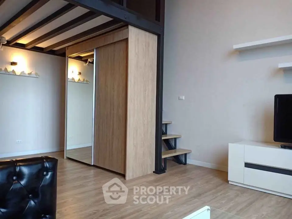 Modern loft-style living room with wooden floors and sleek furniture.