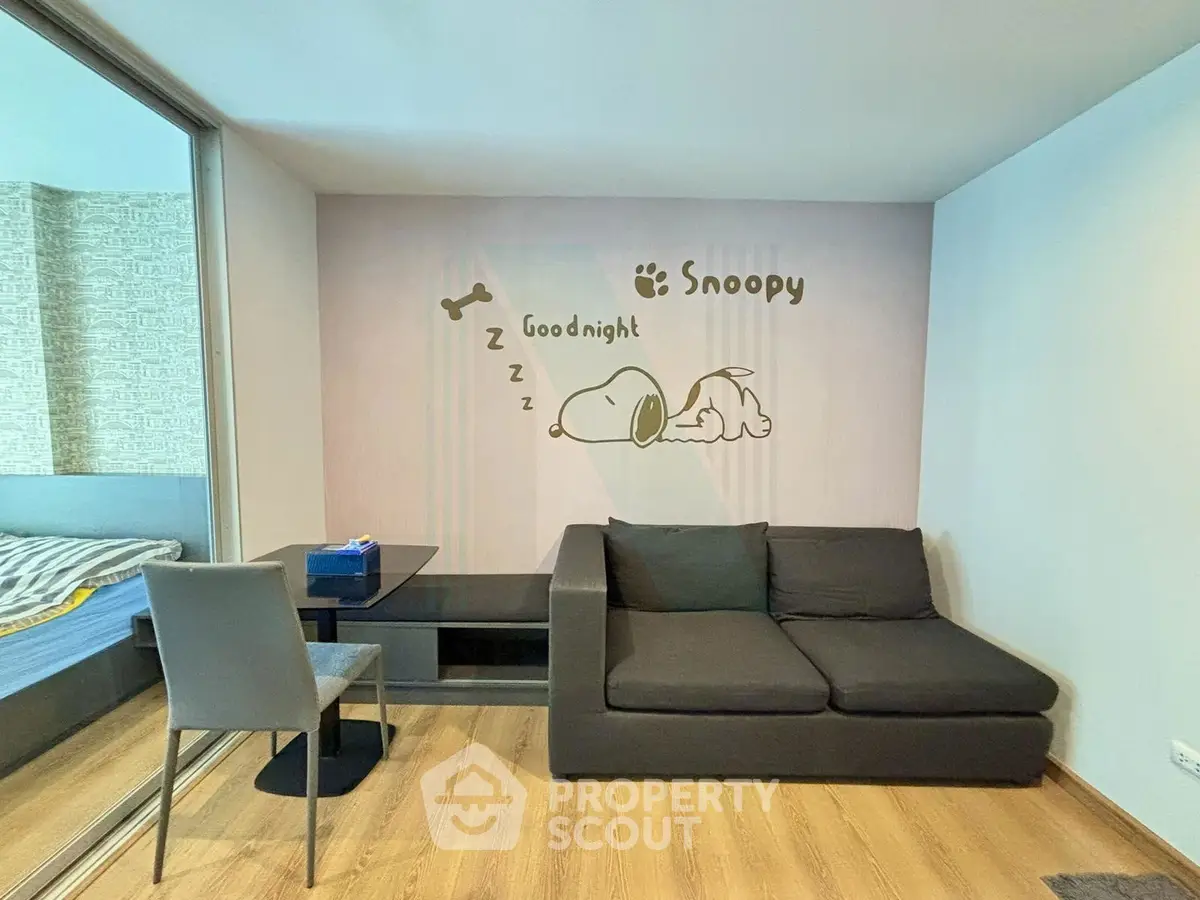 Cozy living room with stylish sofa and Snoopy wall art, perfect for relaxation and comfort.