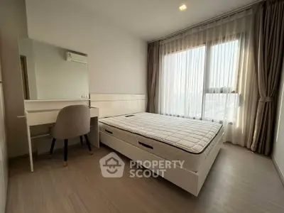 Modern bedroom with large window and stylish furniture in a bright apartment.