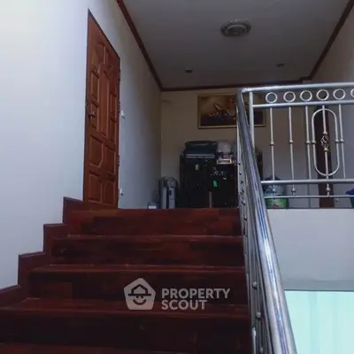 Elegant staircase with wooden steps and metal railing in a residential property