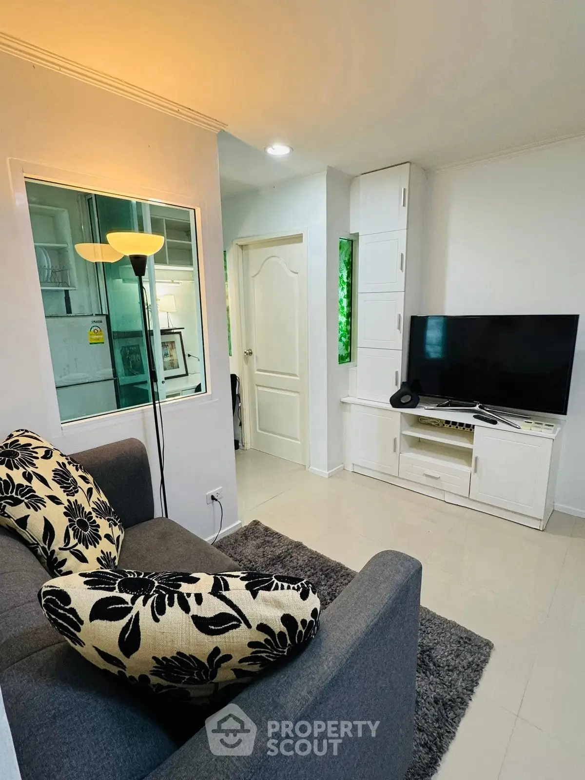 Cozy living room with modern decor and flat-screen TV, perfect for relaxation.