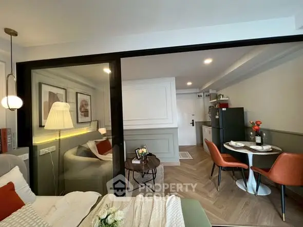Modern studio apartment with cozy living area and dining space, featuring stylish decor and natural lighting.