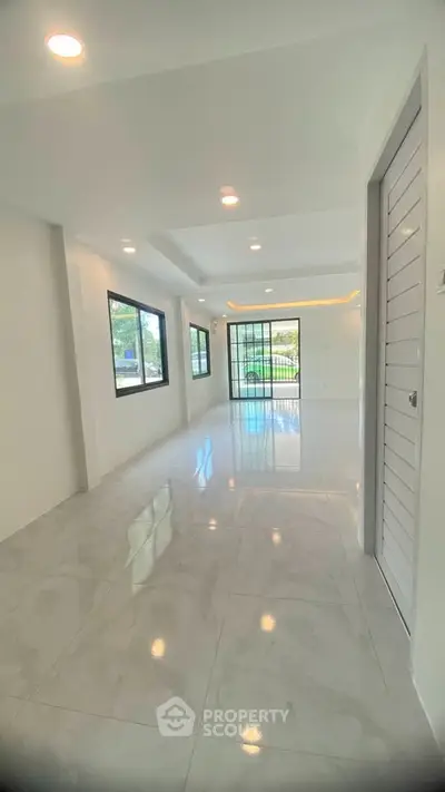 Spacious modern living room with large windows and glossy tile flooring