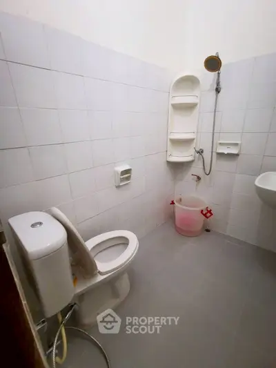Minimalist bathroom with white tiles and basic fixtures