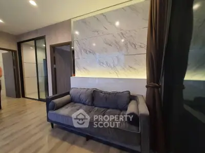 Modern living room with stylish sofa and marble accent wall