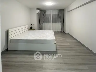 Spacious minimalist bedroom with modern flooring and natural light