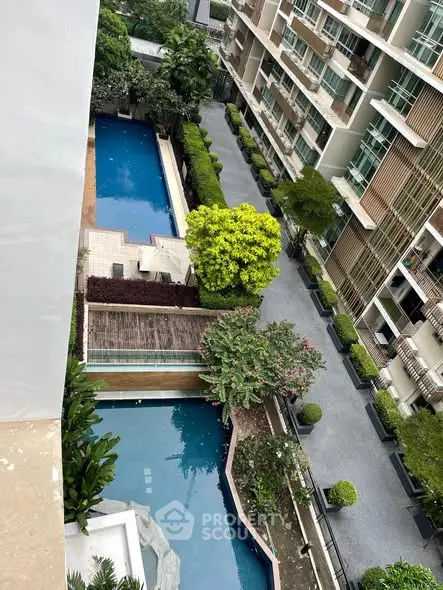 Luxurious apartment complex with stunning pool and lush greenery