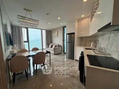Luxurious open-layout kitchen and dining area with ocean view, modern appliances, and elegant decor.