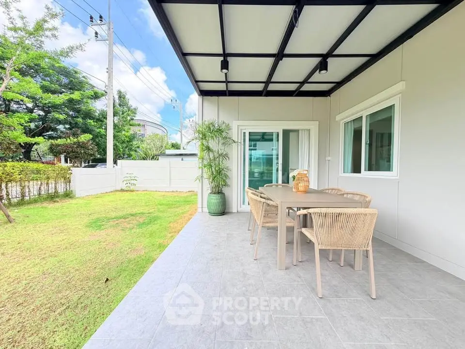 Charming outdoor patio with modern dining set and lush garden view, perfect for relaxation and entertaining.