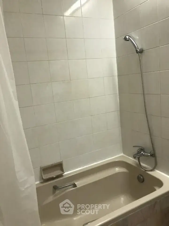 Cozy bathroom with classic bathtub and shower combo, perfect for relaxation.