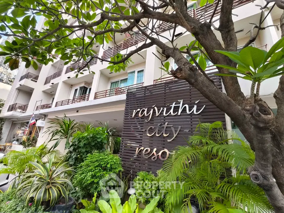 Modern urban residential building with lush greenery and stylish signage