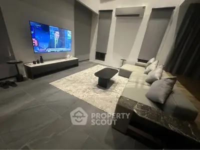 Modern living room with sleek furniture and wall-mounted TV, perfect for relaxation and entertainment.