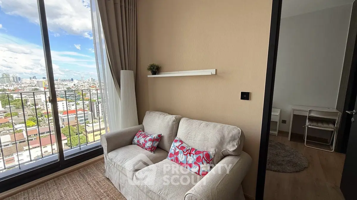 Cozy living room with city view from balcony, featuring a plush sofa and modern decor.