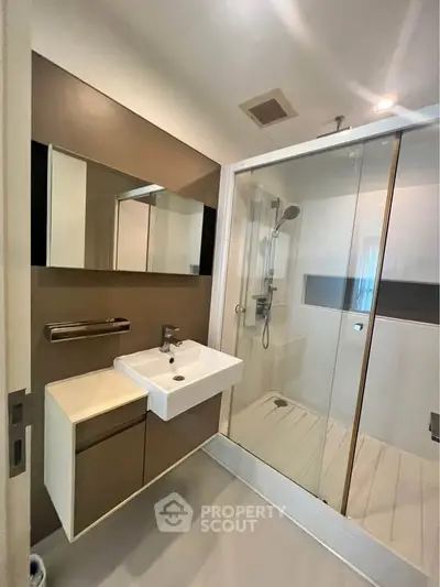 Modern bathroom with sleek shower and stylish vanity in contemporary apartment.