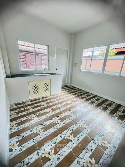 Bright kitchen with floral tile flooring and ample natural light