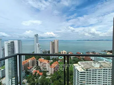Stunning high-rise balcony view overlooking ocean and cityscape, perfect for urban living with breathtaking scenery.