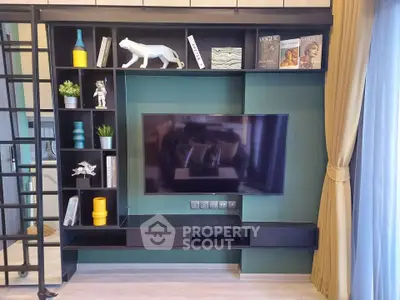 Modern living room with stylish shelving and mounted TV, featuring decorative accents and natural light.