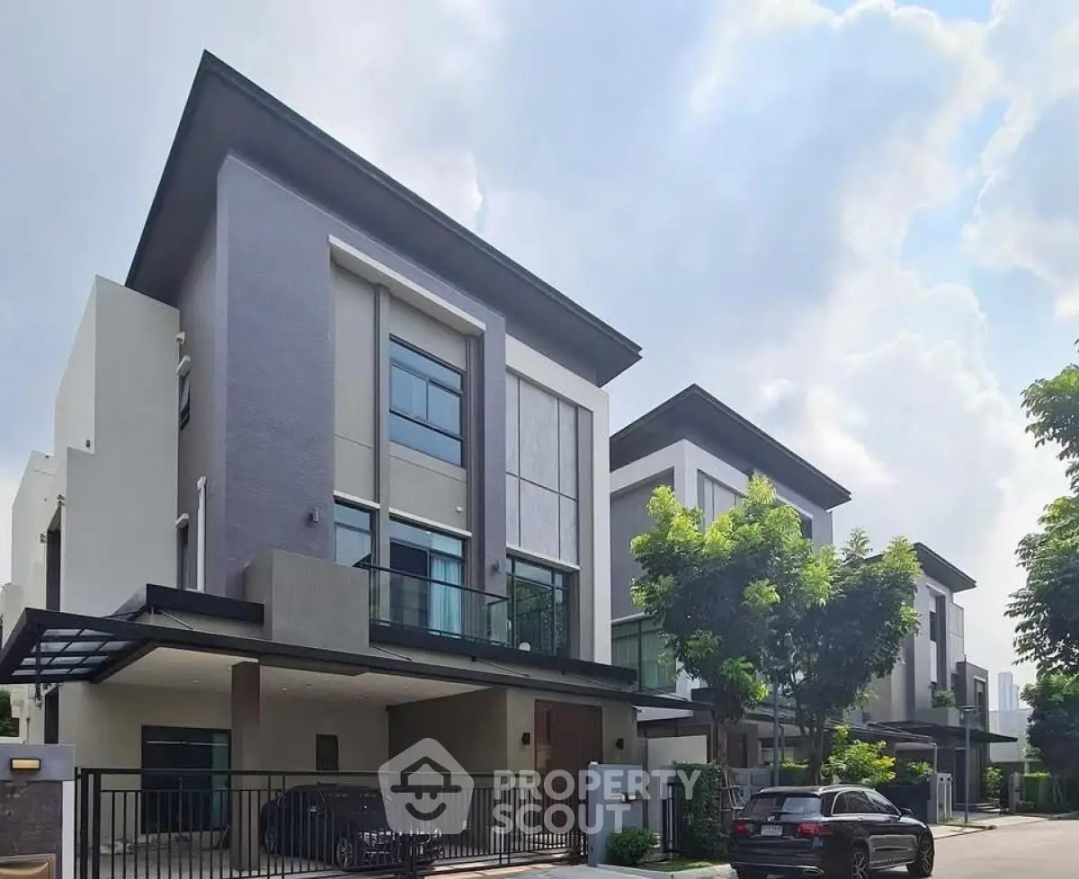 Modern three-story houses with sleek design and lush greenery in a serene neighborhood.