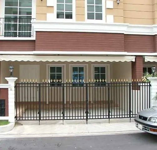 Elegant townhouse exterior with gated entrance and classic design.