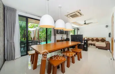 Spacious modern living room with dining area and garden view, featuring stylish lighting and contemporary furniture.