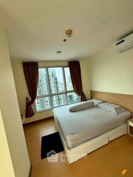 Spacious bedroom with large window offering city views, featuring a comfortable bed and modern decor.