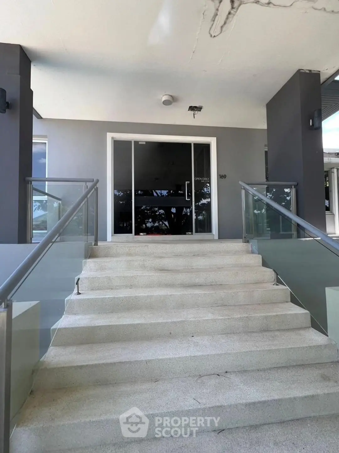 Modern building entrance with sleek glass railings and steps