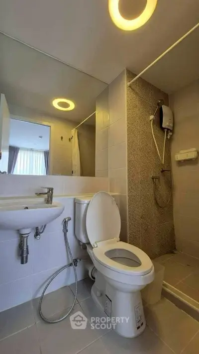 Modern bathroom with shower and sleek fixtures in contemporary apartment.
