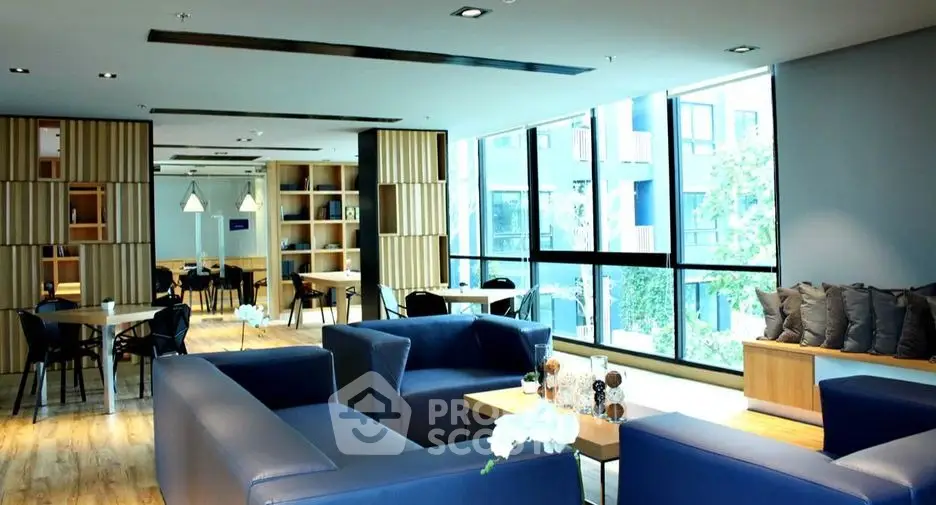 Modern living room with blue sofas and large windows in a stylish apartment