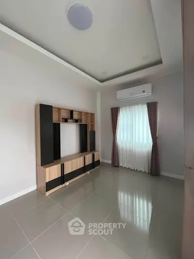 Modern living room with sleek entertainment unit and air conditioning