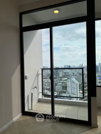 Stunning cityscape view from high-rise balcony with glass doors and tiled floor.