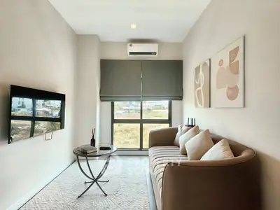 Modern living room with stylish sofa, wall art, and large window view.