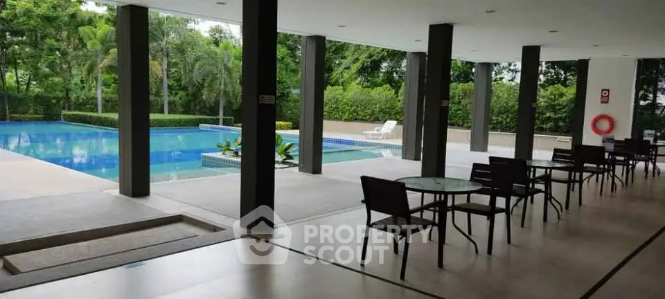 Luxurious poolside area with modern seating and lush greenery, perfect for relaxation and entertainment.