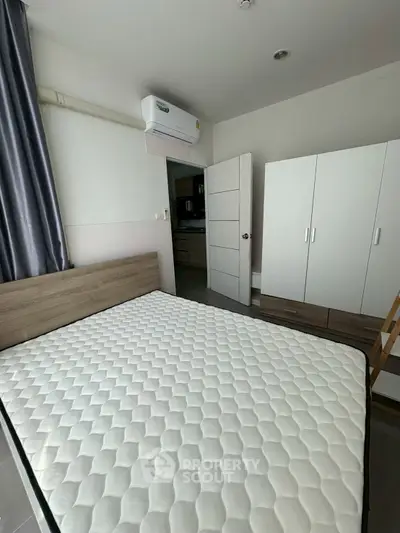 Modern bedroom with air conditioning and wardrobe, featuring a comfortable mattress and sleek design.