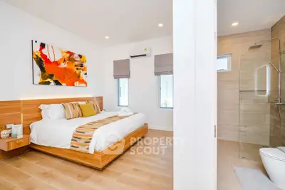 Modern bedroom with ensuite bathroom featuring wooden flooring and contemporary decor.