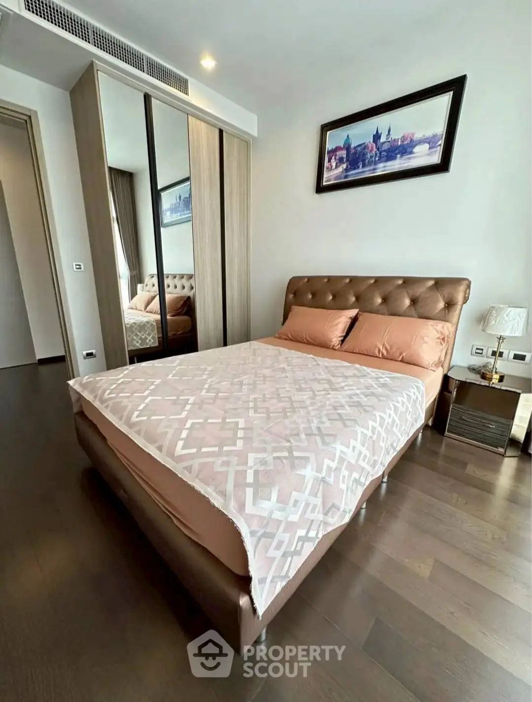 Modern bedroom with stylish decor and wooden flooring in a contemporary apartment.
