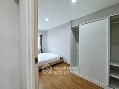 Spacious bedroom with wooden flooring and built-in wardrobe