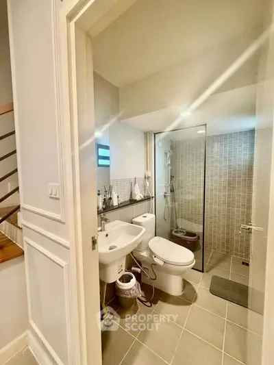 Modern bathroom with glass shower and sleek fixtures in a stylish home.