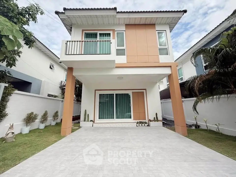 Modern two-story house with spacious driveway and lush garden, perfect for family living.