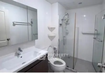 Modern bathroom with glass shower and sleek vanity in a contemporary home.