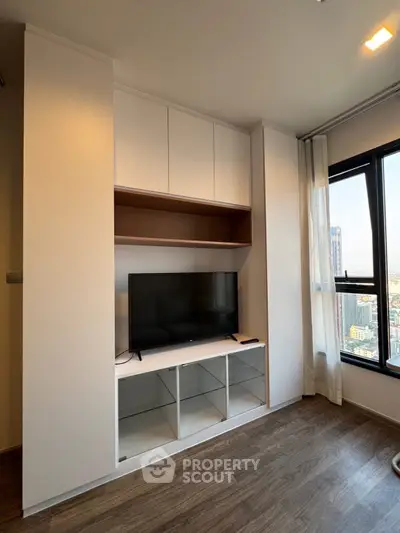 Modern living room with built-in TV cabinet and large window view
